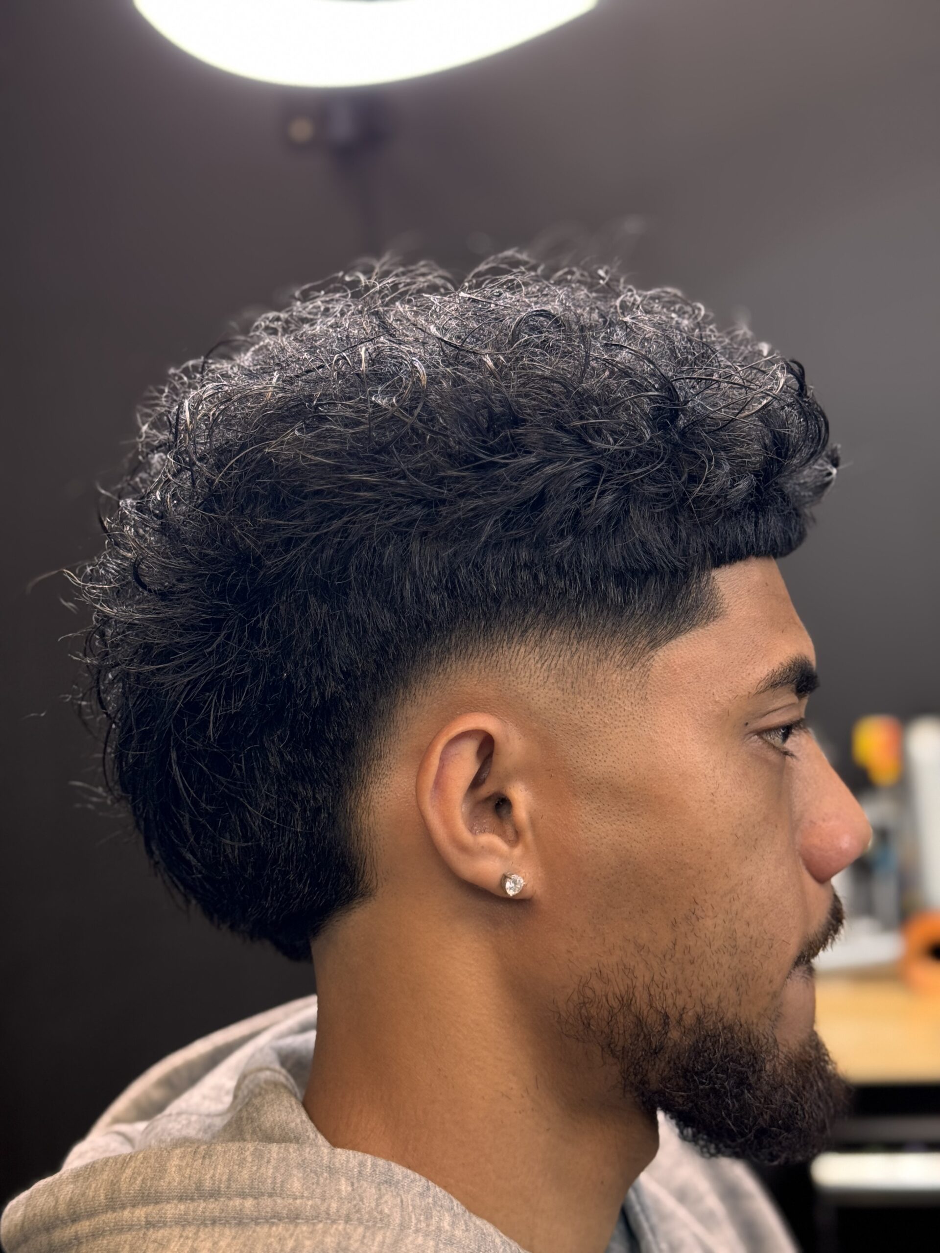 Curly hairstyle with faded sides.